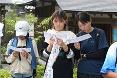 2026年の武者修行：お寺でお経の紙を手にする参加者たち